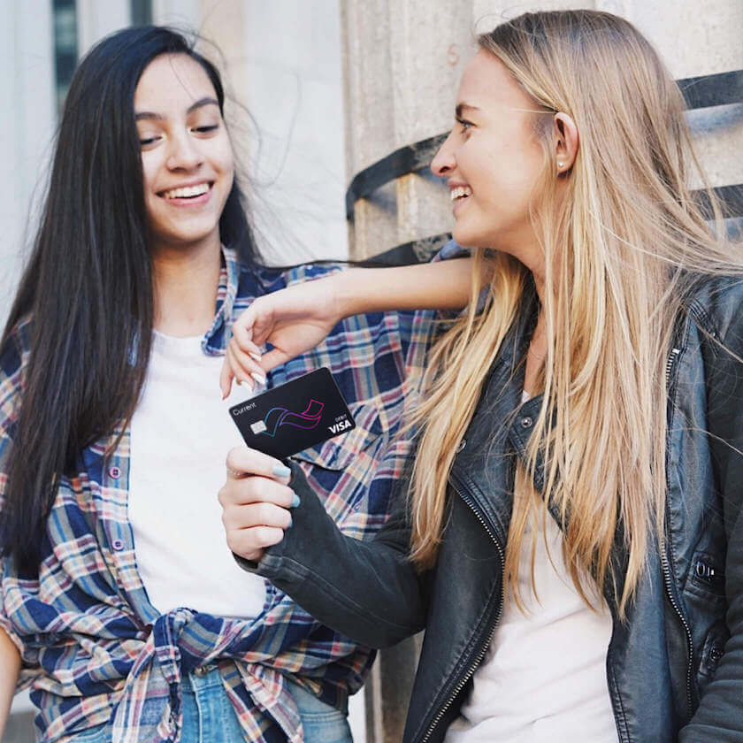 teen holding current bank teen banking debit card with smile